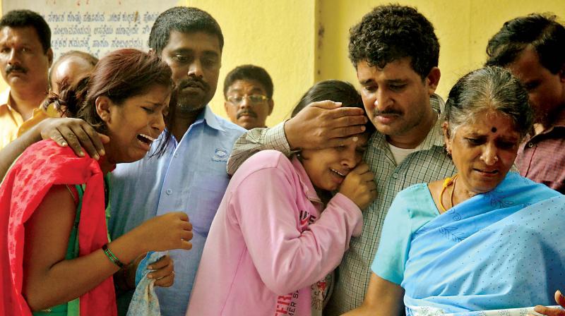 Relatives of Bharati (38), Ramesh (42) and Jagadish (46) grieve at the  mortuary at Victoria Hospital in Bengaluru on Saturday (Photo:DC)