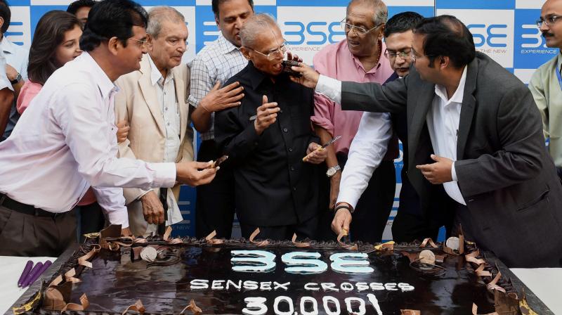 People celebrate with a 30 kg cake at BSE as the Sensex hits 30k mark in Mumbai on Wednesday. (Photo: PTI)
