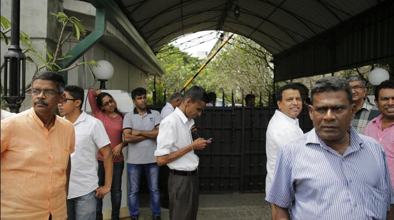 Supporters of sacked Sri Lankan Prime Minister Ranil Wickeremesinghe gather outside his official residence on Sunday. (Photo: AP)