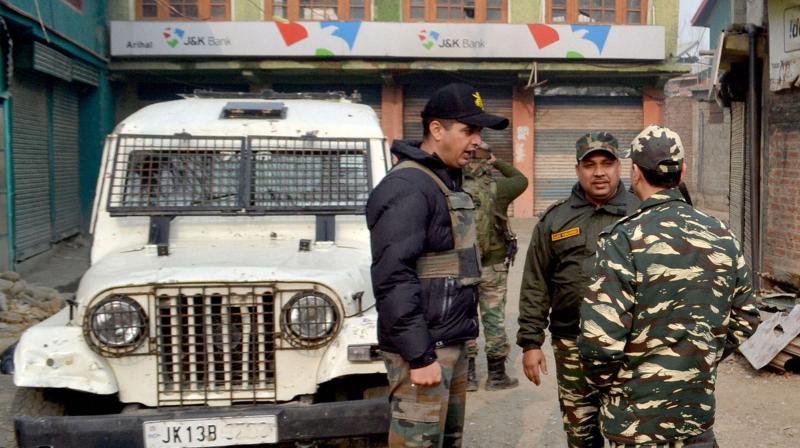 Senior Police and Army officers inspecting Outside Jammu and Kashmir Bank which was looted by unknown gunmen,at Arihal in Pulwama district of south Kashmir on Thursday. (Photo: PTI)