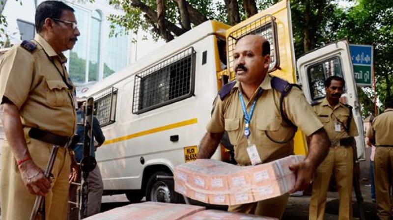 Currency notes being carried from a bank chest amid tight security. (Photo: PTI)
