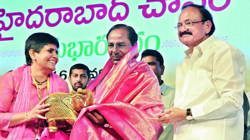 Chief Minister K. Chandrasekhar Rao receives a memento from Deepa Venkat, the managing trustee of Swarna Bharat Trust, after the inauguration of the trust building at Muchintala village in Shamshabad near Hyderabad on Monday. Ms Venkat is the daughter of Union I&B and urban development minister Venkaiah Naidu (right). 	(Photo  DC)