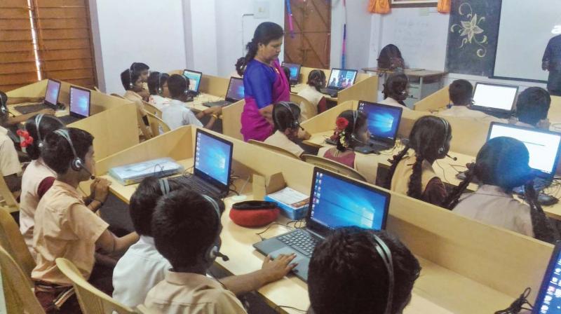 Students of the government school in Hosur sit before computer terminals to learn English. (Photo: DC)