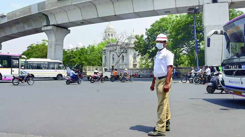 A traffic cop stands on duty near the assembly on a hot summer afternoon. The traffic police have distributed cool vests for cops on duty, but this cop did not receive one. (Photo: DC)