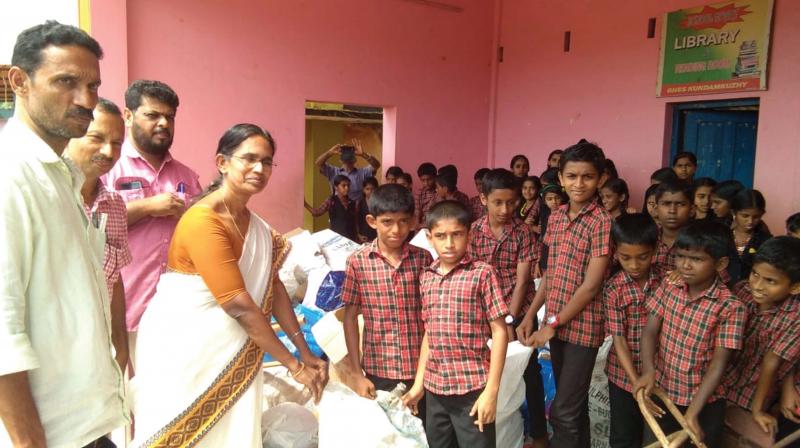 Students hand over scrap items collected from their houses to the District Panchayat officials.