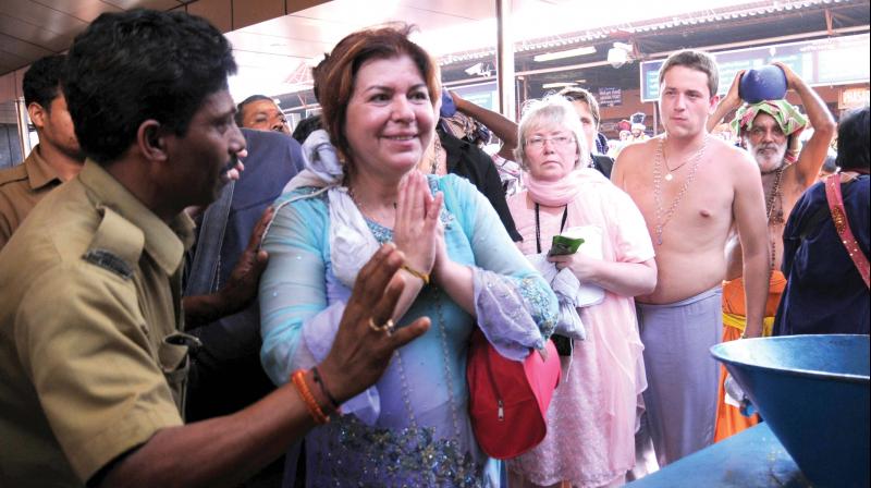 A policeman helps an elderly foreigner woman take a darshan at Sabarimala temple. (file pic)