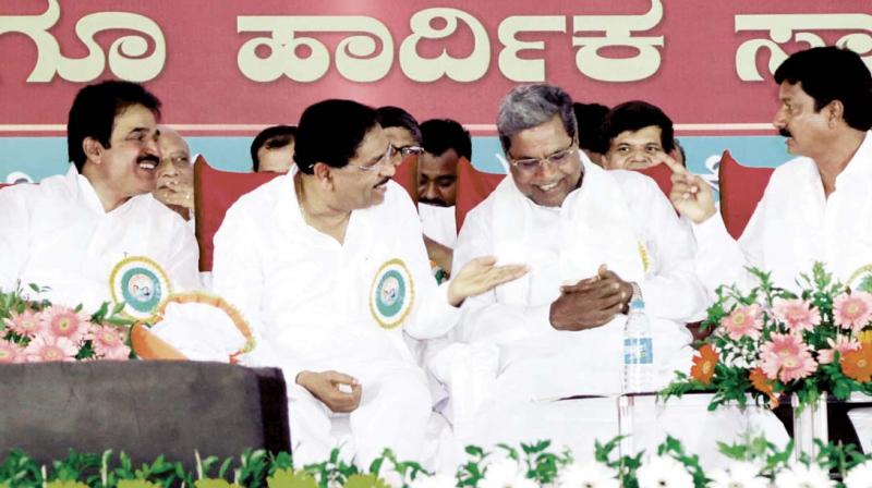 AICC General Secretary in-charge of Karnataka K.C. Venugopal, KPCC President Dr G. Parameshwar and Chief Minister Siddaramaiah share a light moment during a Congress workers rally at Athani in Belagavi district on Friday 	 KPN