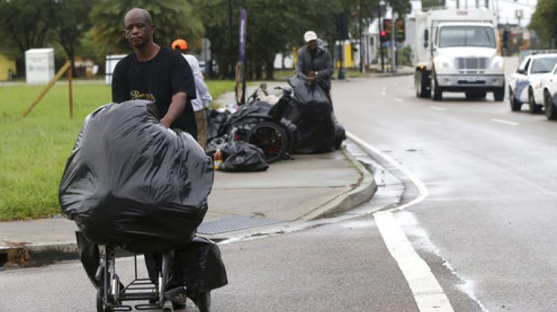 Homeless people move along with their belongings as sanitation employees perform a homeless sweep in New Orleans, in advance of approaching Hurricane Nate, Saturday. (Photo: AP)