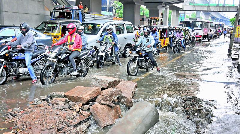 Malakpet main road is flooded making travel difficult for office goers after the heavy showers in Hyderabad on Thursday morning. (Photo: P.Surendra)