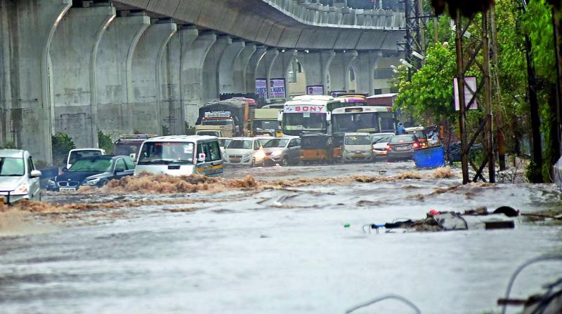 Commuters making their way through flooded streets early in the morning in Uppal as heavy rains pounded the city on Thursday.  (Photo: Gandhi)