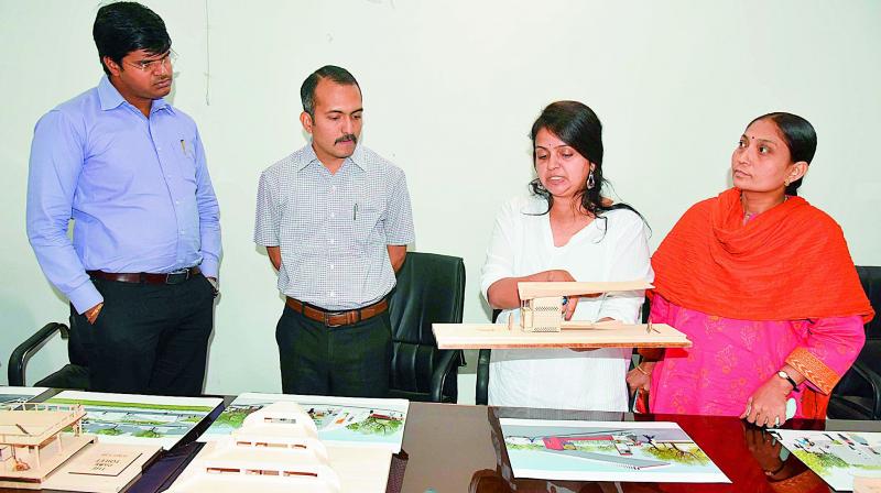 Mayuri Sisodia showing the designs of the model toilets to collector P.J. Patil and GWMC Commissioner VC Goutham. (DC)