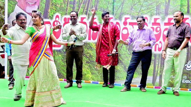 Corporator Ummadi Venkateswara Rao dances with the programme anchor while VMC staff encourage them at garden party on the occasion of Karthika masam at Kotthuru Tadepalli near Vijayawada on Friday. (Photo: DC)