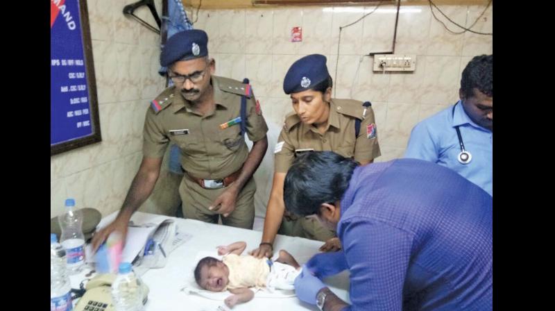 RPF police personnel give necessary first aid to the rescued child at MMC railway station on Saturday. (Photo:  DC)