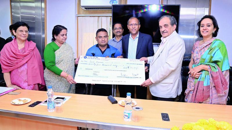Union minister of steel Chaudhury Birender Singh presents the cash cheque to a Para Olympian, Jeet Kumar, as a financial assistance under CSR initiative by the RINL-VSP on Monday in the presence of CMD of RINL-VSP, P. Madhusudan.