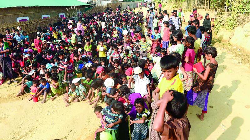 Rohingya refugee children wait for food at a food distribution center in Thankhali refugee camp in the Bangladeshi district of Ukhia on Thursday. (Photo:  AFP)
