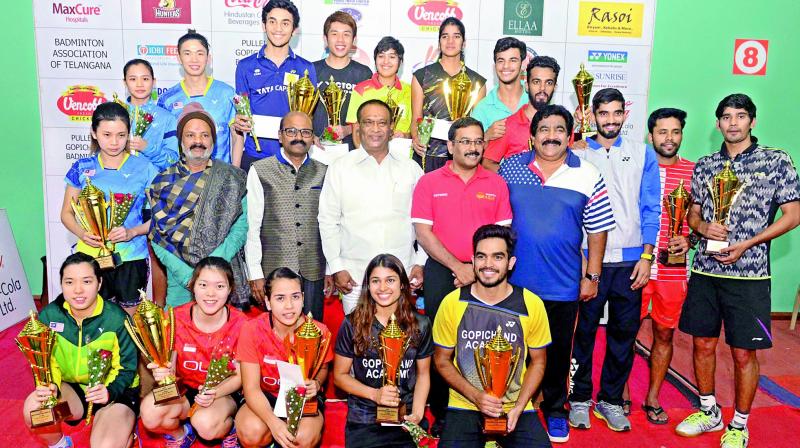 Winners and runners up are all smiles as they pose with their trophies in the India International Series badminton championship on Sunday. Also seen in the pictures are Sports Authority of Telangana State officials.