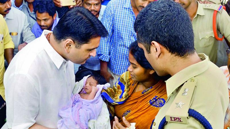 Collector Karthikeya Mishra hands over the infant kidnapped from GGH to its mother in Kakinada on Sunday.