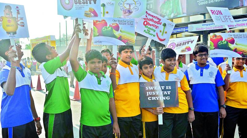Students take part in 3K walk to create awareness on obesity in Vijayawada on Sunday. (Photo: DC)
