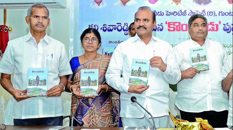 Minister P. Pulla Rao, Kondaveedu Heritage Society general secretary and author  K. Siva Reddy launch a book on Kondaveedu in Guntur city on Sunday. (Photo: DC)