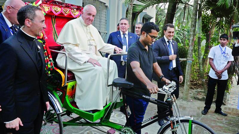 Pope Francis is carried on a traditional Bangladesh rickshaw as he arrives at an interfaith and ecumenical meeting for peace in the garden of the archbishops residence, in Dhaka, Bangladesh, on Friday. (Photo:  AP)