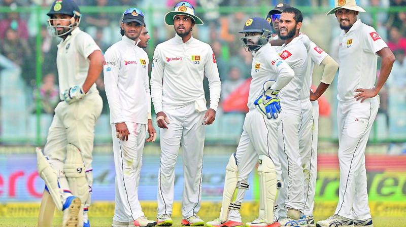 Sri Lanka team players wait for a review decision against Rohit Sharma (left) during their third Test match against India at the Feroz Shah Kotla Cricket Stadium in New Delhi on Sunday. (Photo: AFP)