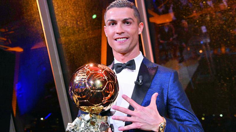 Cristiano Ronaldo poses after receiving his fifth overall Ballon dOr (Golden Ball) trophy on Thursday in Paris. Now, Ronaldo and Lionel Messi are both at level with five Ballon dOr awards each to their names. (Photo:  AP)