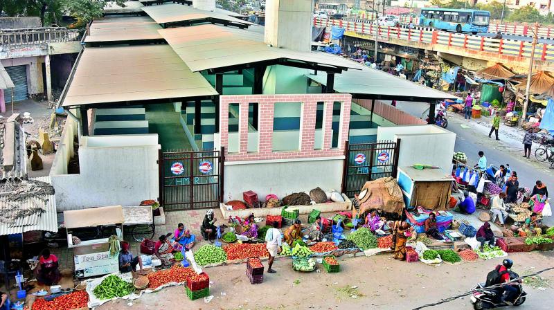 Vegetable vendors do business outside the HMR sheds provided to them at Bharathnagar Metro station on Saturday.