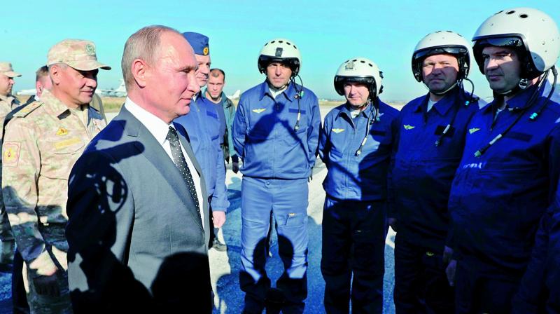 Russian President Vladimir Putin chats with Russian military pilots at the Hmeimim air base in Syria, on Monday. (Photo: AP)