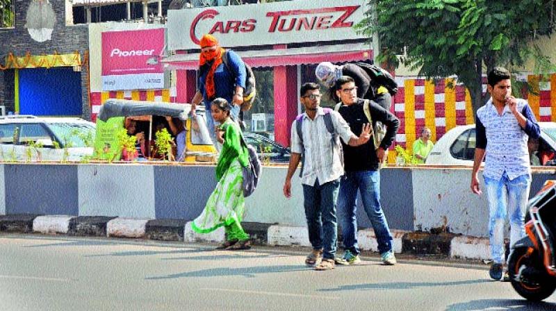Pedestrians jump over a Metro Rail footpath, near Anand Theatre, as there is no opening to cross over. (Photo: DC)