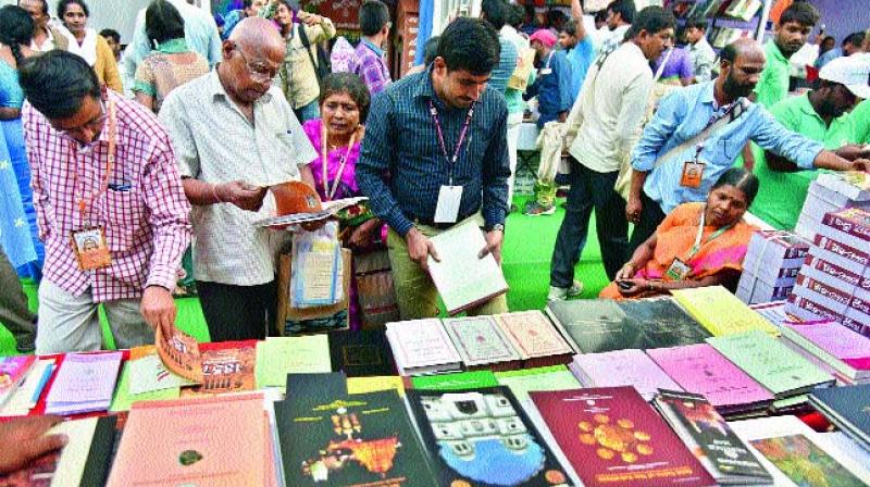 Visitors to the book fair held at the World Telugu Conference go through Telugu books on Saturday. (Photo: DC)