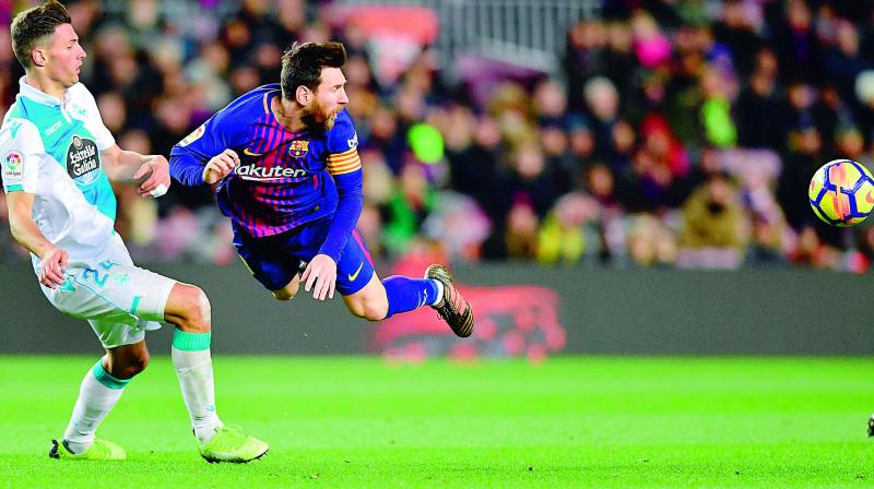 Lionel Messi (right) and Deportivo La Corunas Fabian Schaer eye the ball during their Spanish league football match at the Camp Nou stadium in Barcelona on Sunday. Barcelona won 4-0. (Photo: AFP)