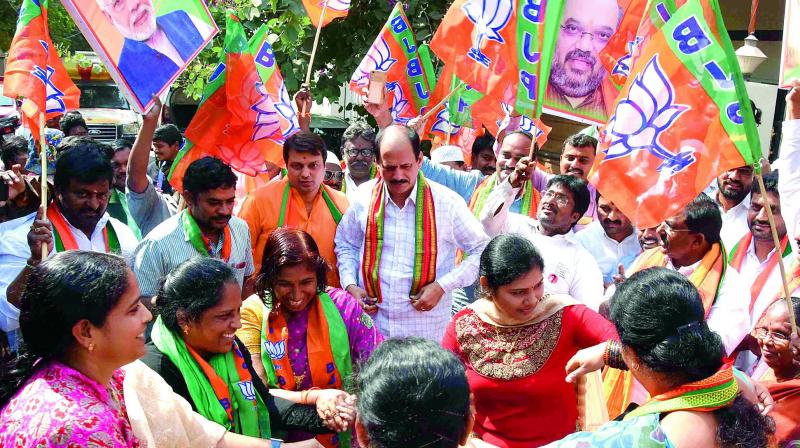Minister P. Manikyala Rao, Narsapuram MP Gokaraju Gangaraju and other activists offer sweets each other and dance in front of state office in Vijayawada. (Photo: DC)