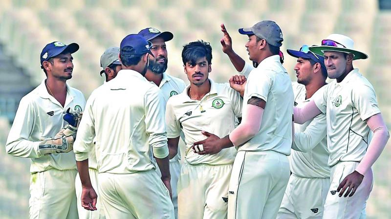 Vidarbha bowler Rajneesh Gurbani (centre) celebrates the fall of a Karnataka wicket with his teammates at the Eden Gardens in Kolkata on Wednesday. (Photo: PTI)