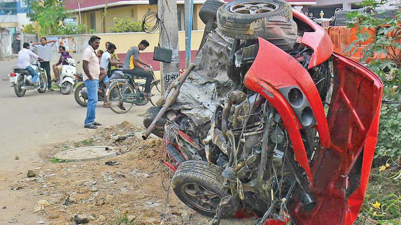 The car which fell of the Irumbuliyur bypass lies in crumbles. (Photo: DC)