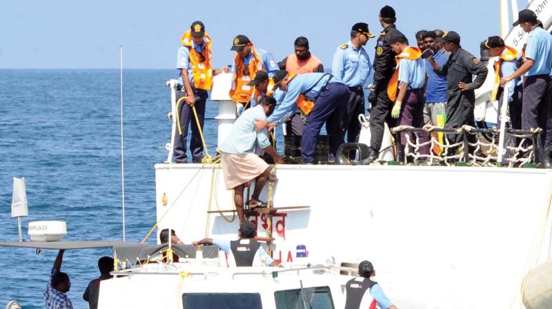The navy personnel take aboard fishermen for the rescue expedition.