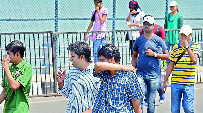 Unable to bear the stench from the Hussainsagar lake, tourists and passersby cover their noses as they walk near the lake. (Photo:Deccan Chronicle)