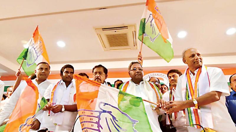 Chief Minister Siddaramaiah and KPCC president Dr G. Parameshwar welcome former BJP minister C.H. Vijayshankar who joined the Congress in Bengaluru on Monday