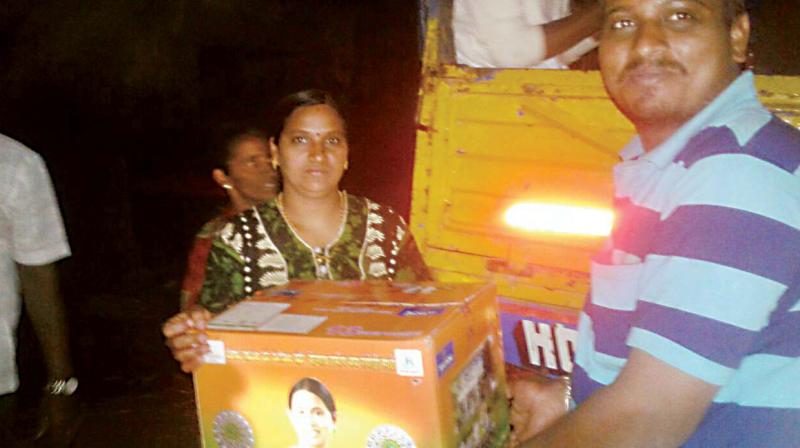A cooker packed in a gift box with the photo of Congress leader Laxmi Hebbalkar being given to a voter in Belagavi Rural constituency