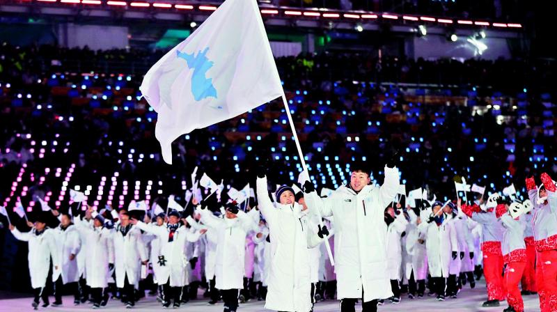 North Koreas Hwang Chung Gum and South Koreas Won Yun-jong lead the joint Korean contingent while carrying a unified Korea flag at the opening ceremony of the 2018 Winter Olympics in Pyeongchang, South Korea, on Friday. (Photo:AP)