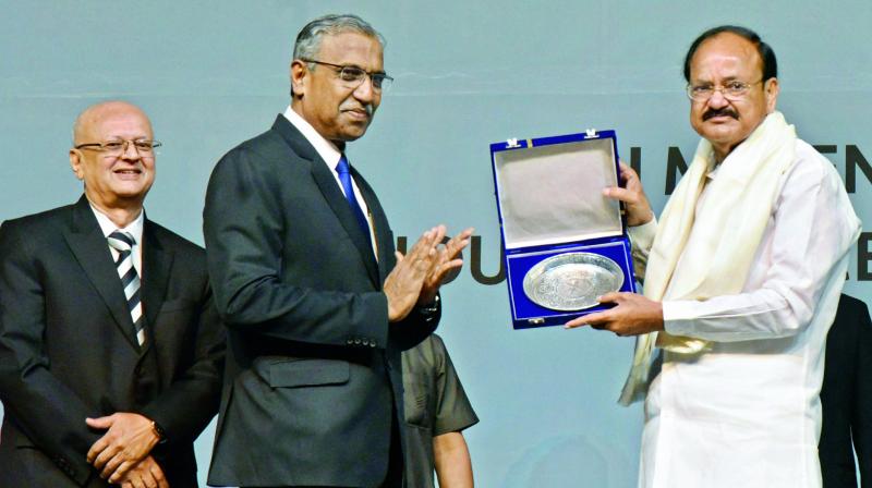 T.S. Vijayan, chairman, IRDAI, presents a memento to Vice-President M. Venkaiah Naidu at the valedictory function of International insurance conference at HICC on Sunday. 	(Photo: DECCAN CHRONICLE)