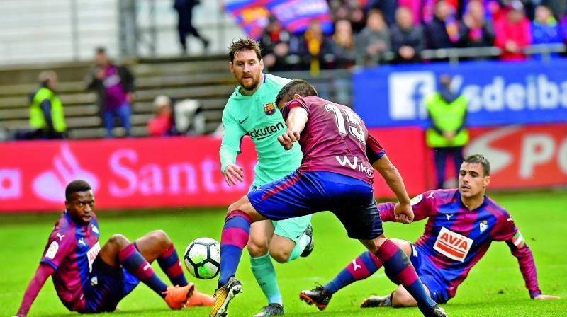 Lionel Messi of Barcelona vies for the ball with players from Eibar during their Spanish league match at the Ipurua stadium in Eibar, northern Spain, on Saturday. Barcelona won 2-0. (Photo:AP)