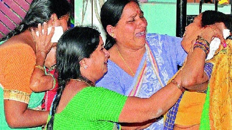 Family members and relatives of accident victims grieve as the bodies of the accident victims were brought at their residence at Amberpet in city on Monday.