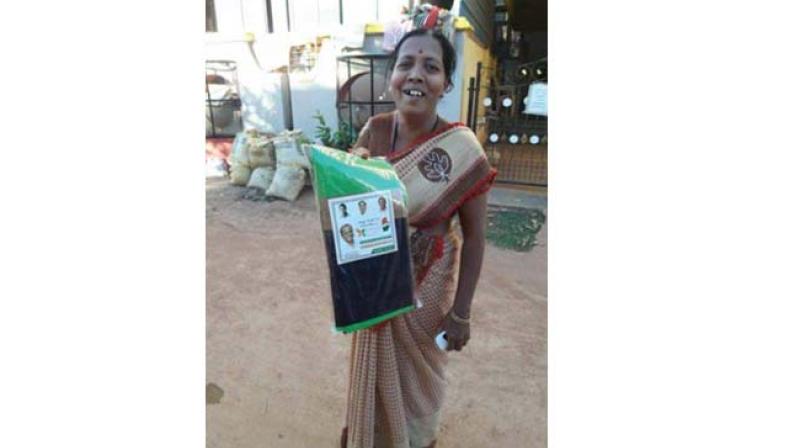 A woman with the saree given to her to attend the Congress convention in Hubballi on Monday. Photo:DC)