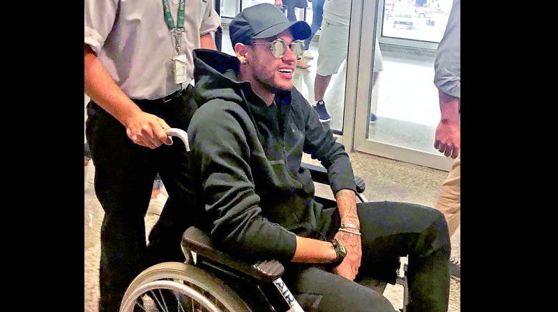 Brazilian superstar Neymar is wheeled at the airport in Rio de Janeiro on Thursday. Neymar suffered a hairline fracture of the fifth metatarsal in his right foot. (Photo:AFP)