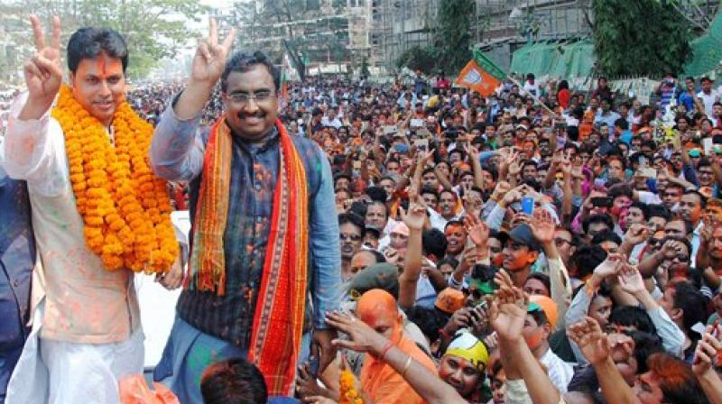 BJP National General Secretary Ram Madhav and Tripura BJP chief Biplab Kumar Deb display victory sign as they celebrate with supporters after partys victory in Tripura Assembly elections results in Agartala on Saturday. BJPs win marks an end to 25 years of CPI-M government rule in the state. (Photo: PTI)
