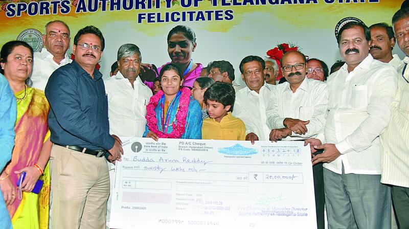 Hyderabad gymnast Budda Aruna Reddy receives a Rs 20 lakh cheque during her felicitation function by the Sports Authority of Telangana State at Lal Bahadur Stadium on Saturday. Also seen on the dais are Telangana Sports & Youth Affairs minister T. Padma Rao Goud, Telangana Tourism & Sports secretary Burra Venkatesham (IAS) and SATS vice-chairman & managing director A. Dinakar Babu.  (Photo:S. Surender Reddy)