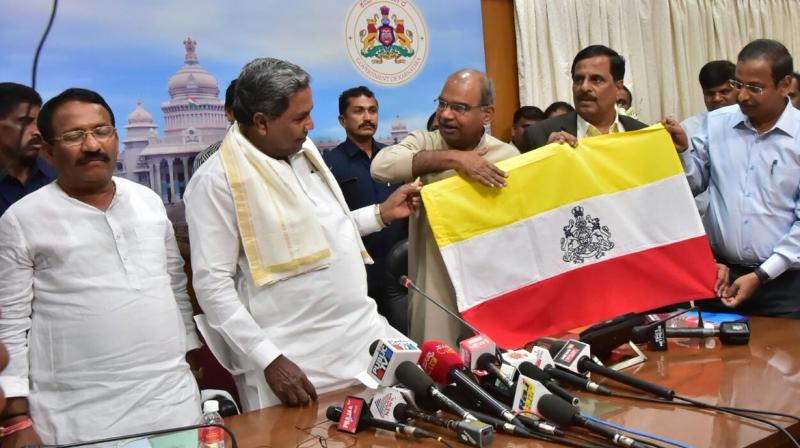 The Siddaramaiah-led Karnataka govt unveiled a yellow-white-and-red flag designed for the state at a meeting on Thursday. (Photo: @CMofKarnataka/Twitter)