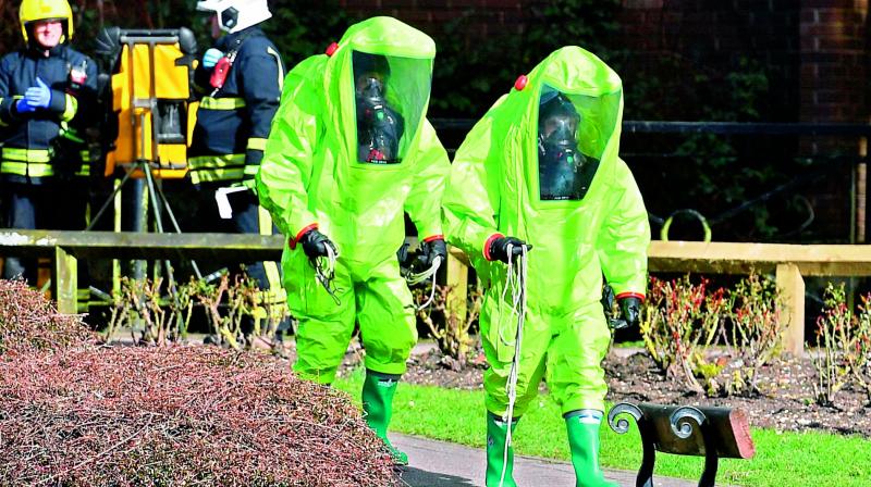 Members of the fire brigade in green biohazard suits work. (Photo:AFP)