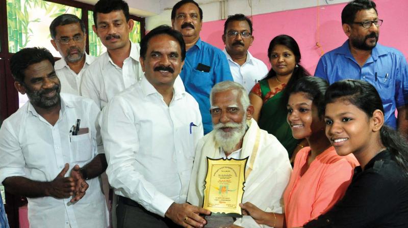 District Collector U.V. Jose honours Kuttan at a function organised to mark World Consumer Day in Kozhikode on Thursday. (Photo:Venugopal)