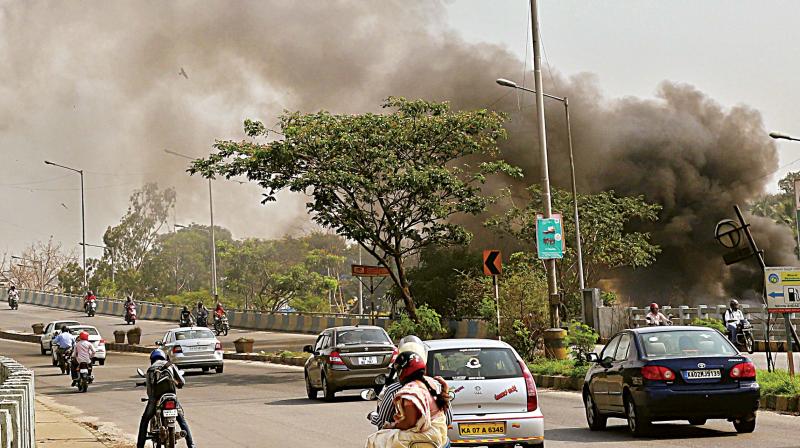 Huge cloud of smoke covering the Ring Road near Sumanahalli Flyover, causing problems to the residents and the motorists due to burning of garbage, in Bengaluru on Sunday.  (Photo:DC)